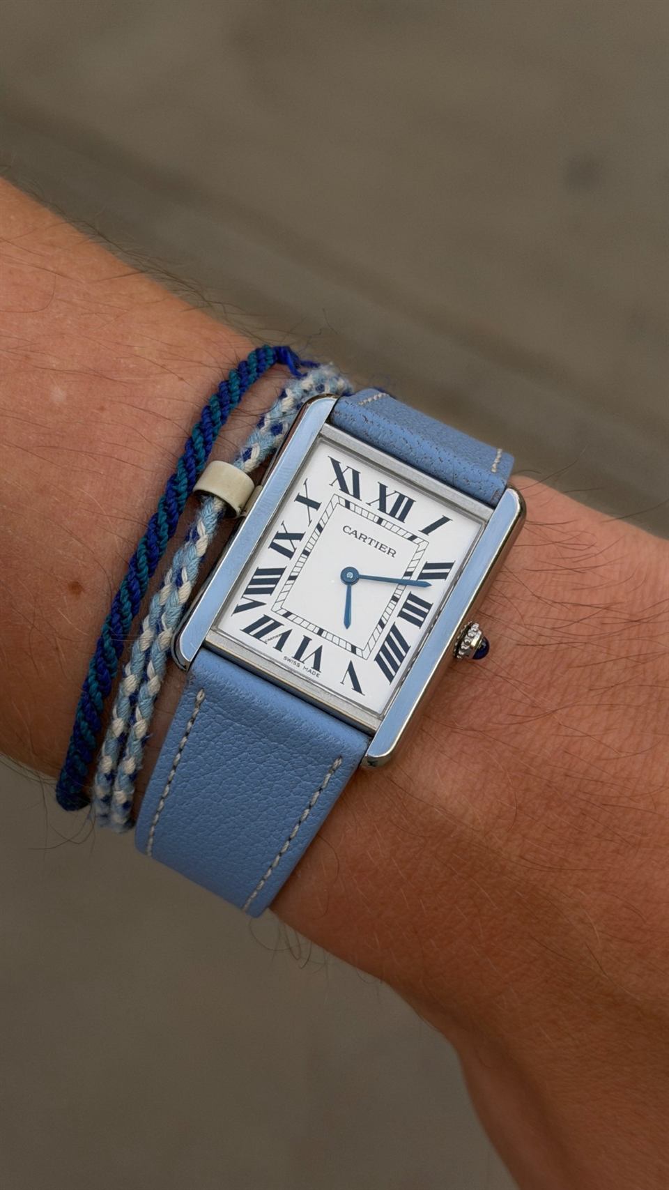 Cartier Tank Must mit hellblauem Lederband am Handgelenk.