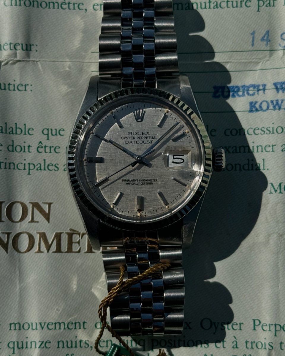 Ältere Rolex Datejust in Stahl am Jubilé-Band, liegend auf dem Chronometer-Zertifikat aus ihrer Zeit