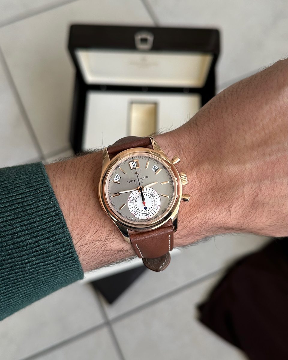 Patek Philippe Chronograph in Roségold am braunen Lederband, dahinter die geöffnete Box