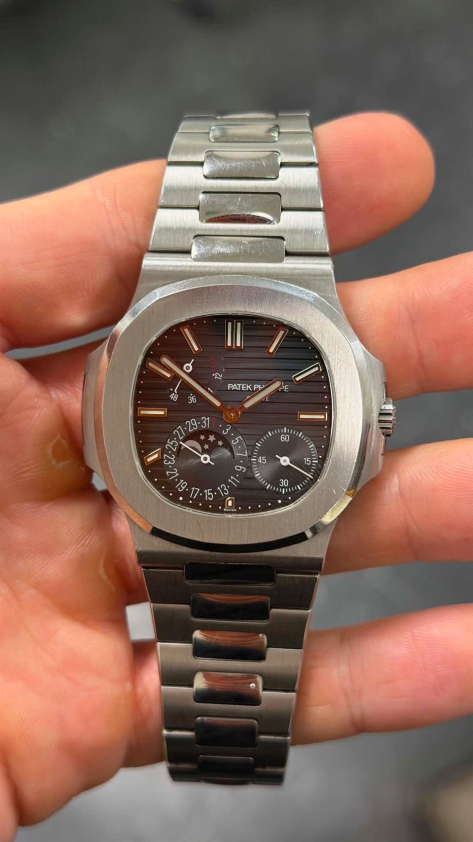 Patek Philippe Nautilus in Stahl mit Stahlband, in der Hand gehalten.