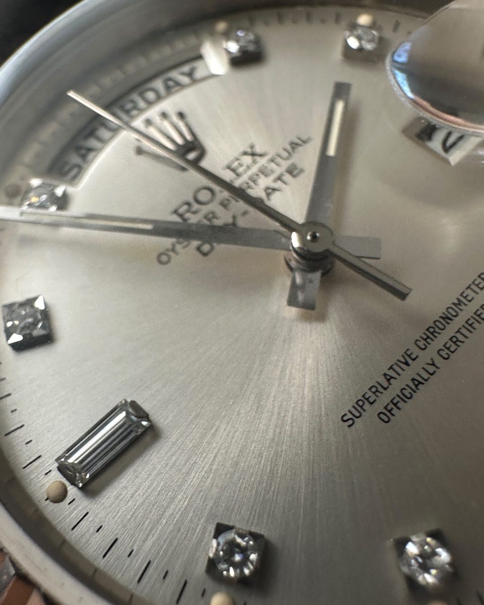 Nahaufnahme eines Rolex-Zifferblatts mit Wochentag, Brillant- und Baguette-Indizes