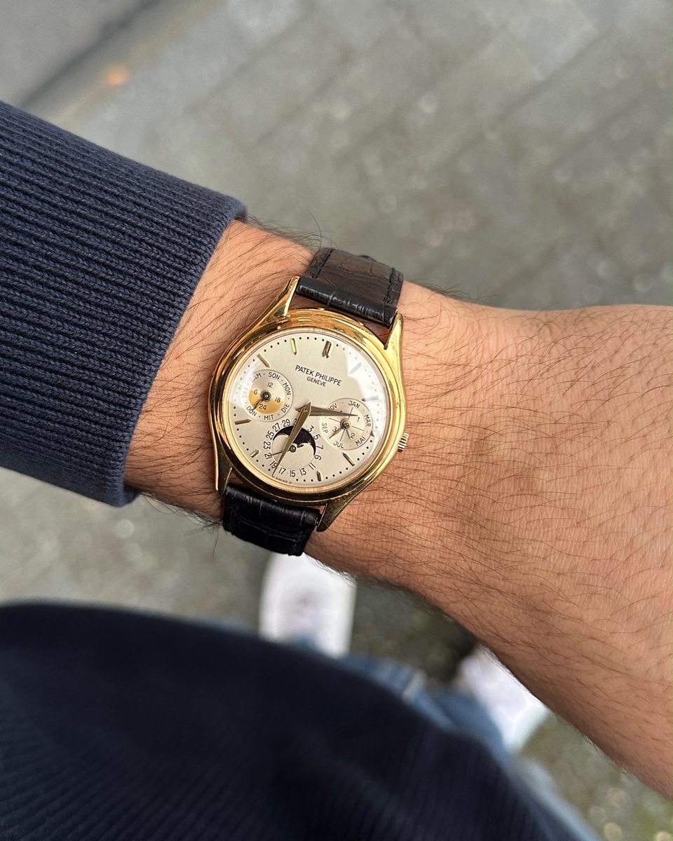 Patek Philippe mit ewigem Kalender und Mondphase in Gelbgold an einem dunklen Lederband am Handgelenk