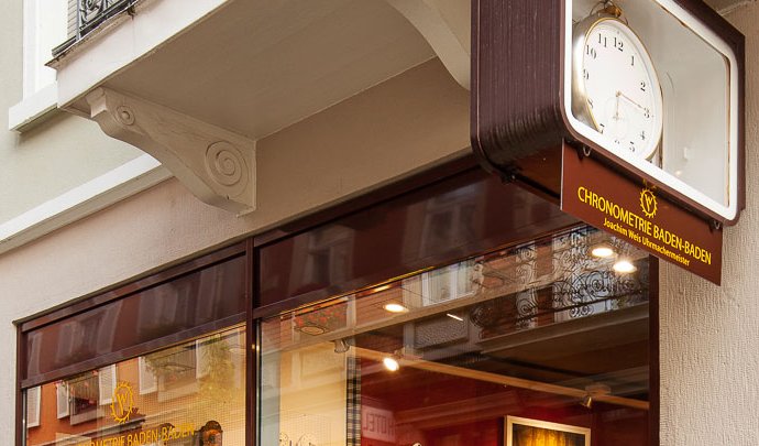 Ladenfront der Chronometrie Baden-Baden in der Merkurstraße 4, mit Schild und Uhr über dem Eingang