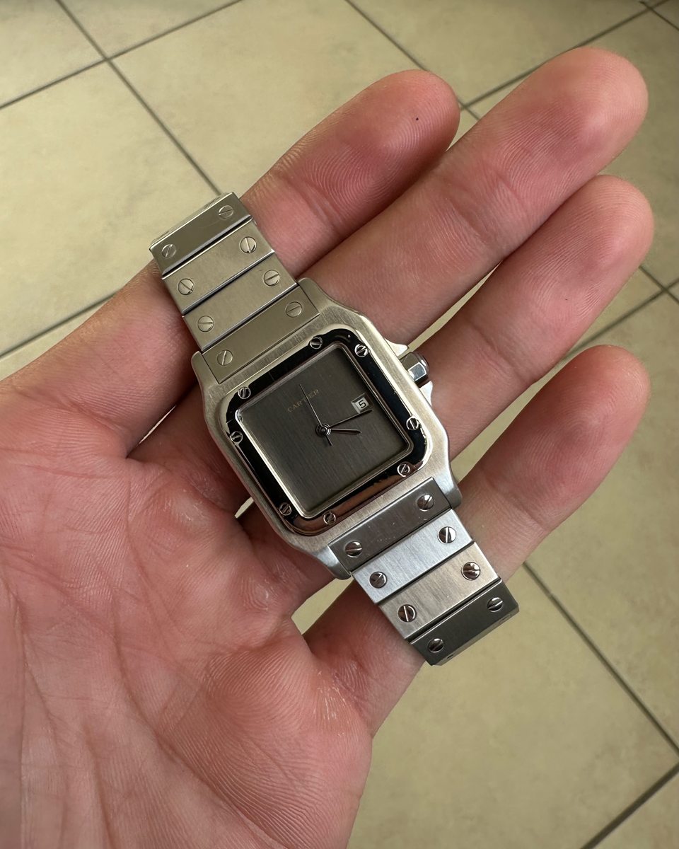Cartier Santos in Stahl mit hellem Zifferblatt in der offenen Hand