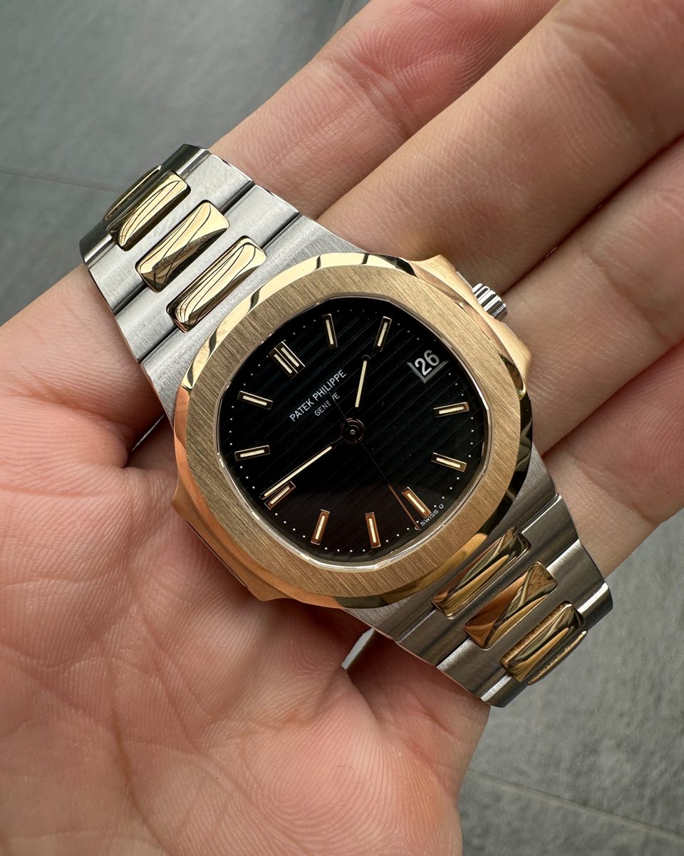 Patek Philippe Nautilus in Stahl und Gold mit schwarzem Zifferblatt in der Hand