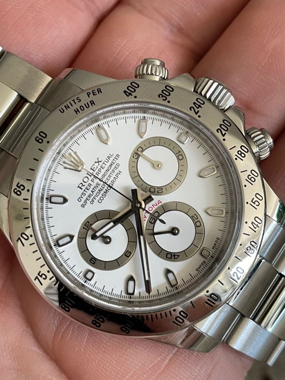 Rolex Cosmograph Daytona in Stahl mit weißem Zifferblatt, in der Hand gehalten.