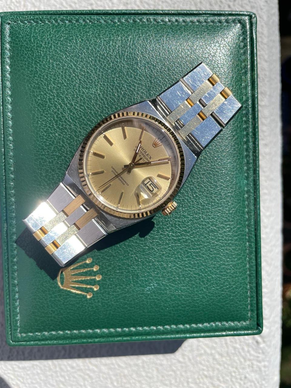 Rolex Datejust Oysterquartz in Stahl und Gold auf einem grünen Rolex-Etui.